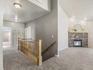 Hall featuring an upstairs landing and carpet flooring