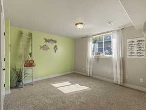 Spare room featuring carpet and a textured ceiling