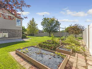 Fenced backyard featuring a patio and a garden
