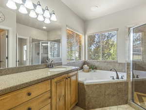 Bathroom with vanity, a shower stall, healthy amount of natural light, and a garden tub
