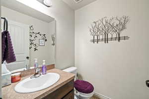 Half bathroom featuring vanity and toilet