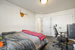 Bedroom with carpet flooring, a desk, and a closet