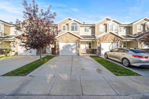 View of front of property with stone siding and concrete driveway