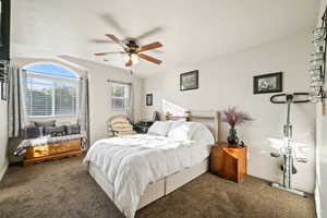 Carpeted bedroom featuring a ceiling fan and baseboards