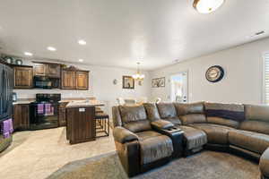 Living room featuring a chandelier, recessed lighting, light tile patterned floors, and a textured ceiling
