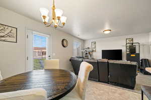 Dining space with light tile patterned flooring and a chandelier
