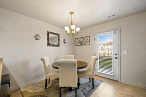 Dining room with a chandelier and light tile patterned flooring
