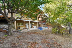 Rear view of property - featuring 3 decks that run the full length of the home.