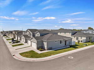 Traditional-style home with a residential view, concrete driveway, stucco siding, stone siding, and a shingled roof