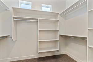Walk in closet featuring dark colored carpet