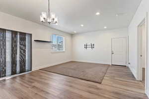 Unfurnished dining area featuring recessed lighting, light wood-type flooring, and a chandelier