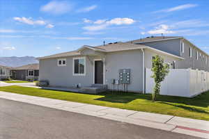 View of front facade with stucco siding, a mountain view, and a shingled roof