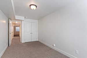 Unfurnished bedroom featuring carpet, a closet, and a textured ceiling