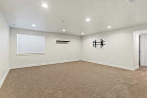 Spare room featuring light colored carpet and recessed lighting