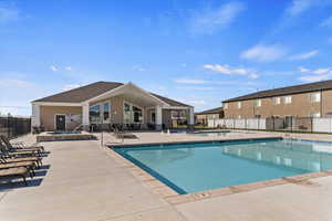 Community pool with a patio area and a hot tub