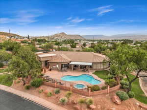 View of pool featuring an in-ground hot tub, a patio, a fenced backyard, and a mountain view
