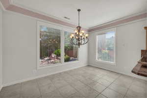 Unfurnished dining area featuring plenty of natural light, a chandelier, and light tile patterned flooring
