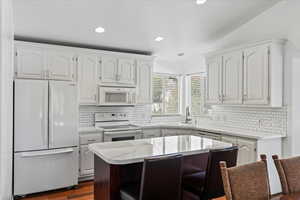 Beautiful kitchen with white cabinets and appliances.