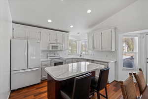 Beautiful kitchen with white cabinets and appliances.
