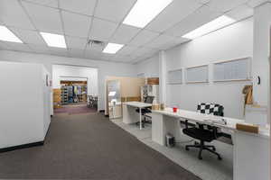 Carpeted home office with a drop ceiling
