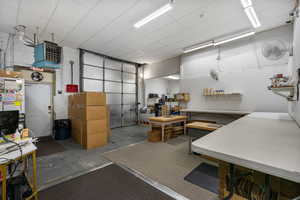 Misc room featuring concrete flooring, a paneled ceiling, and a heating unit