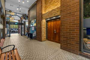 Lobby featuring a towering ceiling and brick wall