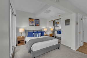 Carpeted bedroom with a closet and electric panel