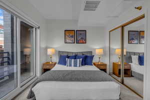 Bedroom with carpet, access to exterior, and a closet