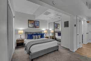 Bedroom featuring light carpet, a closet, and electric panel
