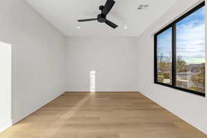Spare room with light wood-style floors, a ceiling fan, and recessed lighting