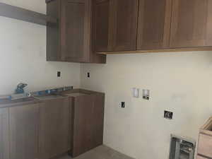 Washroom featuring hookup for a washing machine and cabinet space