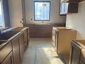 Kitchen featuring healthy amount of natural light, exhaust hood, and brown cabinets