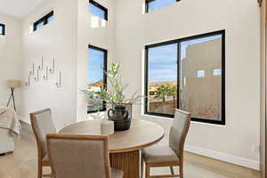 Dining space featuring plenty of natural light, wood finished floors, and a high ceiling