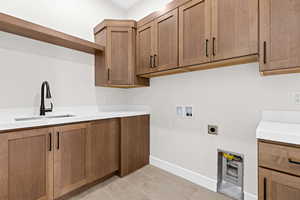 Laundry area with washer hookup, light tile patterned floors, hookup for an electric dryer, and cabinet space
