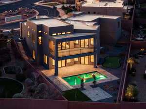 Rear view of house featuring a patio, a balcony, stucco siding, a pool with connected hot tub, and a putting green
