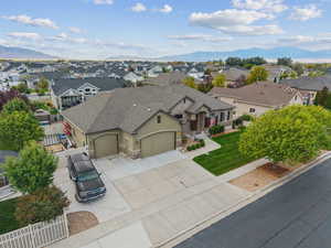 View of front facade with a garage, stone siding, driveway, stucco siding, and a residential view