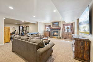 Living area with light colored carpet, recessed lighting, a fireplace, and a barn door