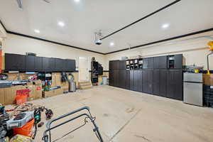 Garage featuring freestanding refrigerator and recessed lighting