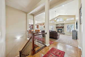 Corridor featuring an upstairs landing, wood finished floors, and high vaulted ceiling