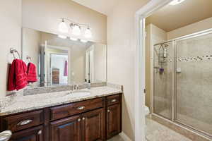 Bathroom featuring vanity, a shower stall, and light tile patterned floors