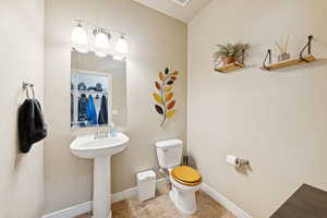 Half bath with toilet and tile patterned flooring