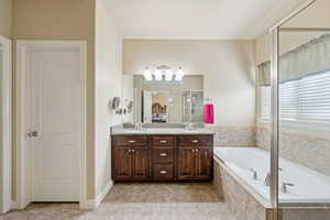 Full bath with double vanity, a bath, a stall shower, and light tile patterned floors