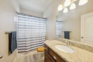 Bathroom with vanity, light tile patterned floors, and shower / bath combo with shower curtain