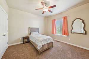 Carpeted bedroom with a closet and a ceiling fan
