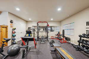 Workout room featuring recessed lighting and dark rubber floors