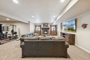 Living room featuring recessed lighting, carpet, and a stone fireplace