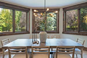 Dining space with wood finished floors and a chandelier