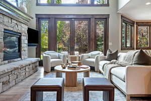 Living room featuring a fireplace, plenty of natural light, wood finished floors, and french doors