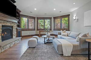 Living area featuring a stone fireplace, recessed lighting, and wood finished floors