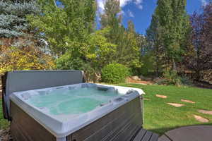 View of green lawn with a hot tub